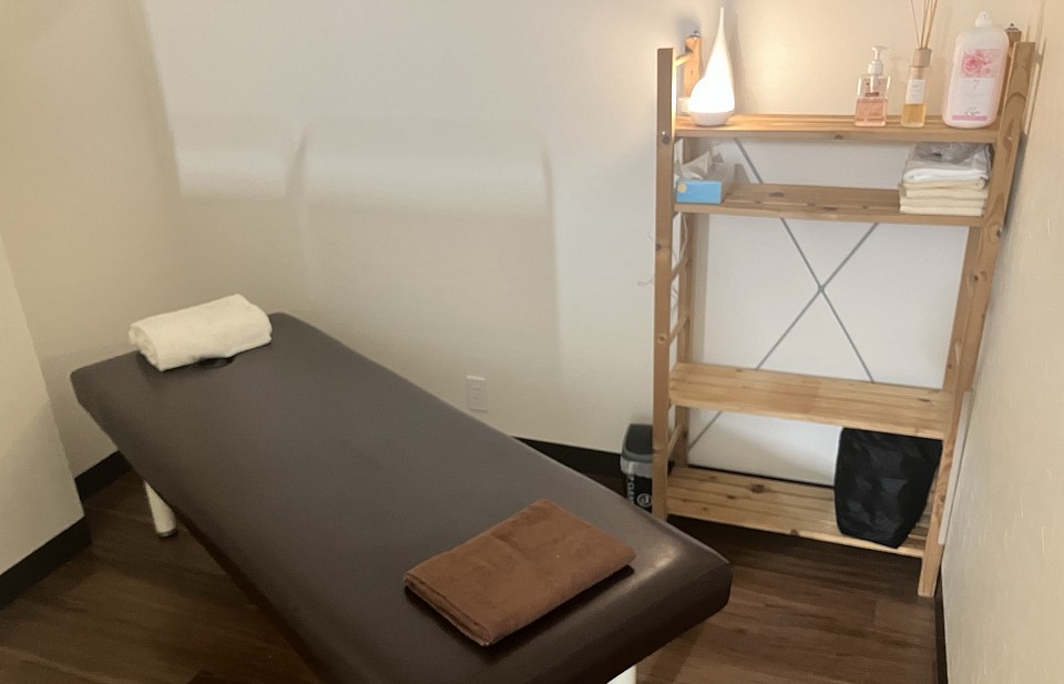 Aroma Luxe  ダウンライトで心も体も癒される、落ち着いた施術ベッドの風景